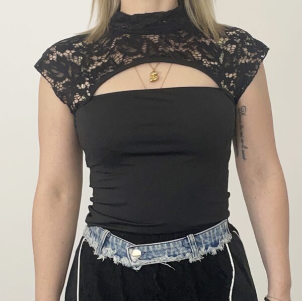 Donna indossa top in pizzo Lycra nero, modello smanicato.