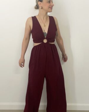 Jumpsuit color bordeaux con scollo a V, cut-out rotondo sul davanti, fianchi elasticizzati e gamba palazzo. Indossata da modella alta 1,60 m, taglia S