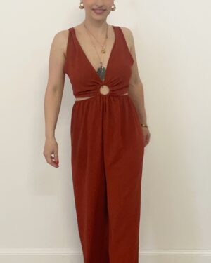 Jumpsuit in tessuto fluido color coccio, con scollo a V e cut-out rotondo al centro. I fianchi sono aperti con fascia elasticizzata che si adatta alle forme. Gamba palazzo ampia e laccetto regolabile dietro la schiena. Modello comodo, femminile e adatto fino alla taglia 48. La modella è alta 1,60 m e indossa la taglia S.
