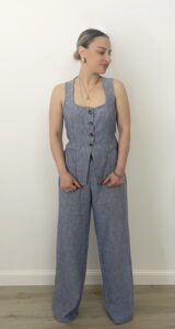 Completo azzurro in chambray con gilet sagomato a bottoni e pantalone a palazzo. Indossato da modella alta 1,60 m, taglia S