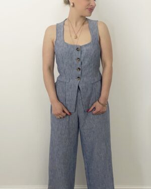 Completo azzurro in chambray con gilet sagomato a bottoni e pantalone a palazzo. Indossato da modella alta 1,60 m, taglia S