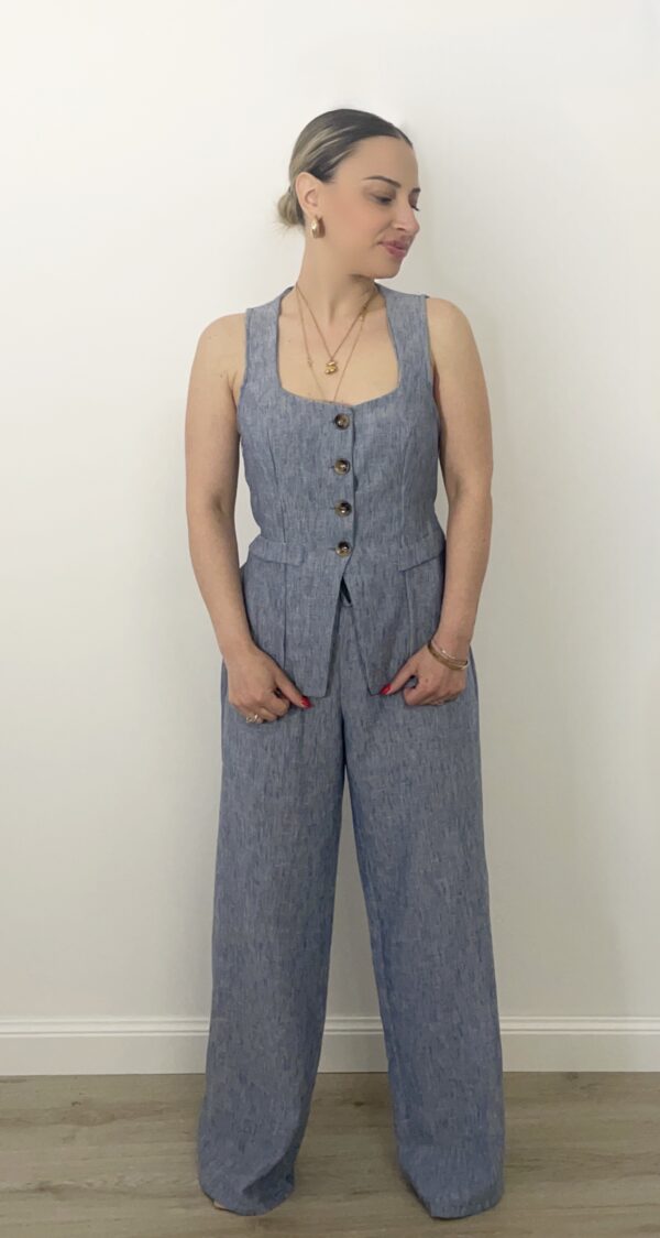 Completo azzurro in chambray con gilet sagomato a bottoni e pantalone a palazzo. Indossato da modella alta 1,60 m, taglia S