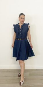 Donna indossa abito corto in denim con volant e cintura in vita