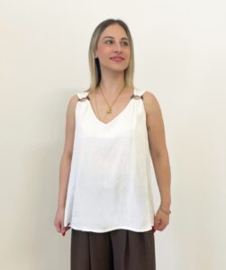 Donna indossa canotta bianca con anelli marroni effetto legno sulle spalline