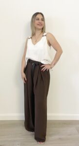 Donna indossa pantalone palazzo marrone con pinces e cintura nera a nastro