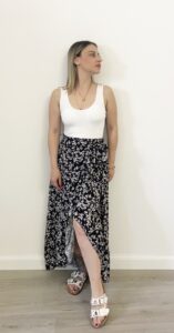 Donna indossa la gonna Bloom Black nera a portafoglio con fiorellini bianchi