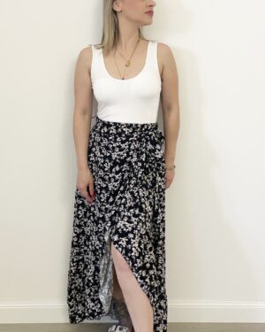 Donna indossa la gonna Bloom Black nera a portafoglio con fiorellini bianchi
