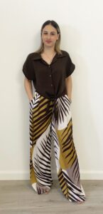 Donna indossa il Pantalone Elba con fantasia foglia stilizzata e taglio ampio