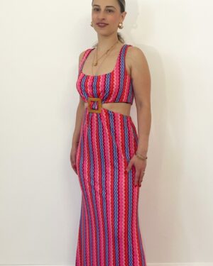 Abito lungo fantasia fucsia e viola con cut-out laterale indossato da modella.