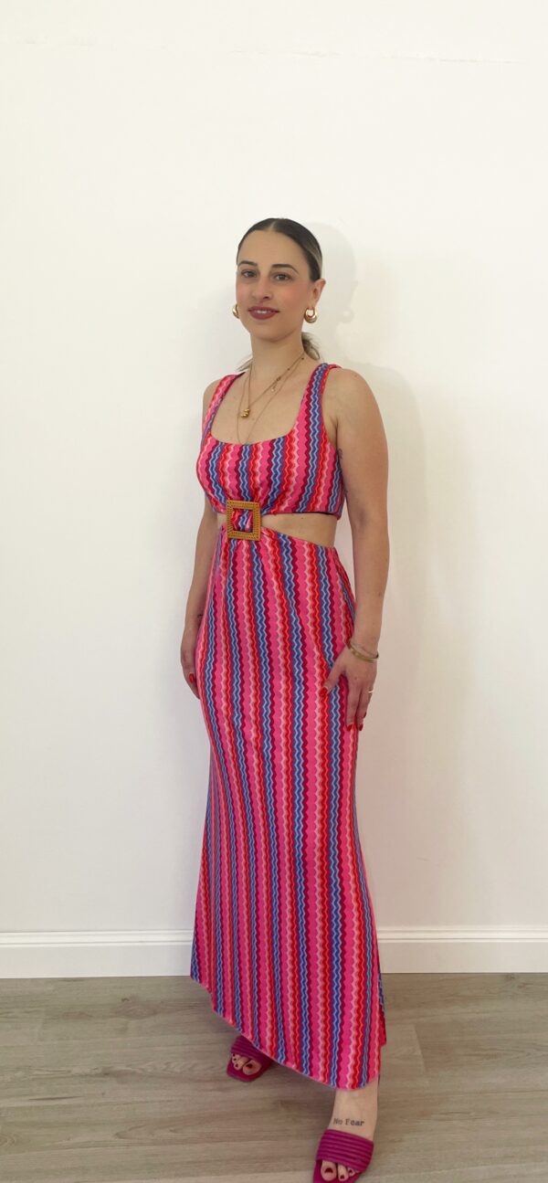 Abito lungo fantasia fucsia e viola con cut-out laterale indossato da modella.