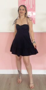 Mini abito blu scuro con bretelle a fiocco e taglio svasato indossato da modella.
