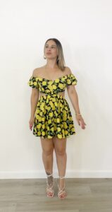 Abito corto a fantasia limoni con spalle scoperte, maniche a palloncino e dettagli cut-out in vita.
