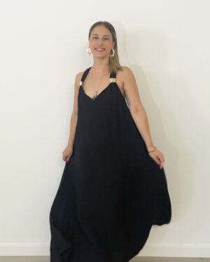 Abito lungo nero over con spalline larghe, dettagli oro sulle bretelle e schiena intrecciata.