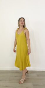 Abito midi giallo senape con spalline annodate e linea morbida.