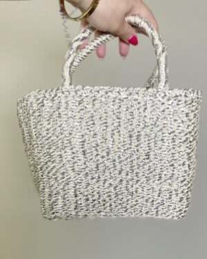 Mini borsa in paglia intrecciata con dettagli filati argento, manici rigidi e tracolla lunga removibile.
