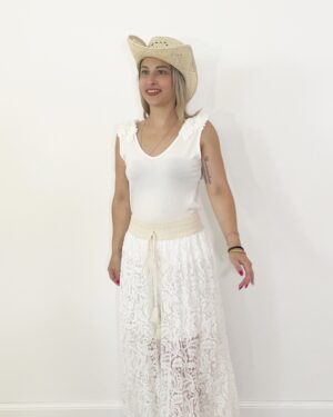 Pantaloni ampi in pizzo beige panna con elastico in vita e fodera interna, indossati con canotta bianca e cappello di paglia.