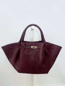 Borsa bordeaux asimmetrica in ecopelle con manici corti e chiusura dorata