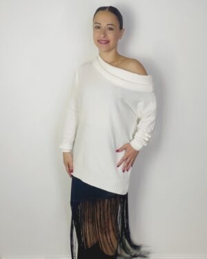 Maxi maglia bianca con scollo a barca e maniche lunghe, indossata con gonna nera con frange