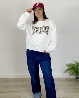 Felpina bianca con scritta New York animalier, scollo rotondo e maniche ampie.