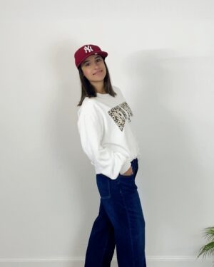 Jeans blu a gamba ampia con maxi risvolto chiaro sul fondo, indossato con stivaletti bordeaux.