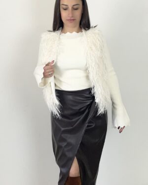 Gonna midi marrone in ecopelle con nodo e drappeggio sul davanti, abbinata a maglia e gilè bianchi.